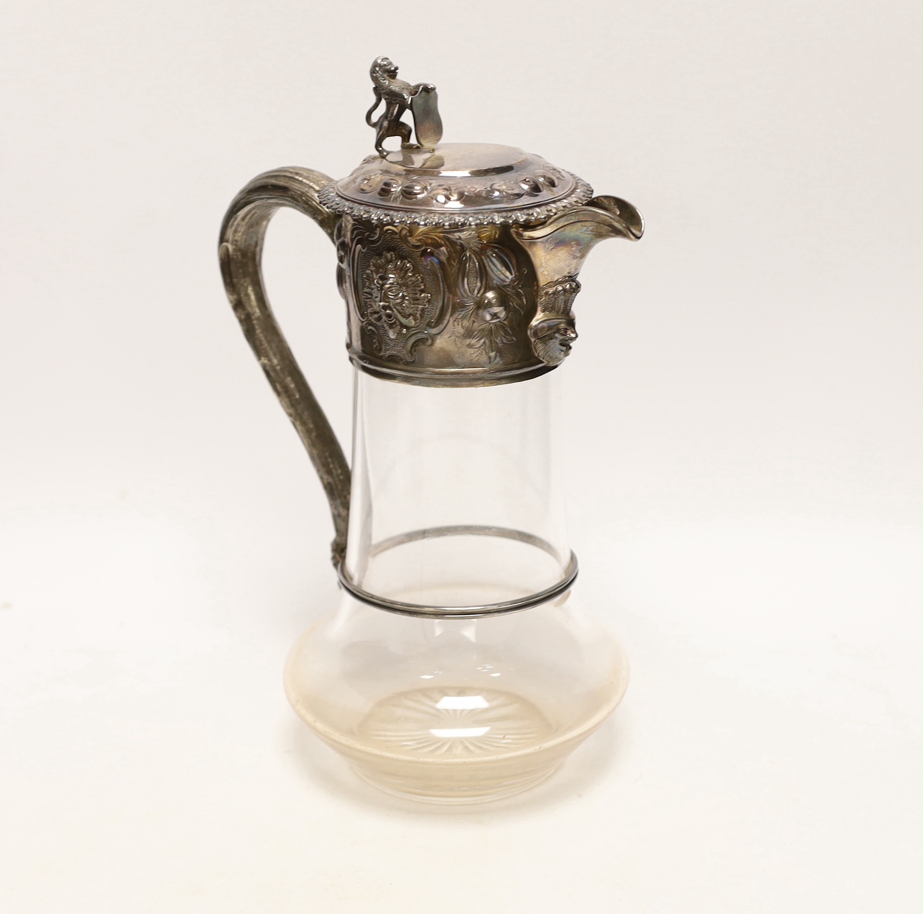 A late Victorian embossed silver mounted glass decanter, with rampant lion finial, Edward Charles Brown, London, 1877, 26.7cm.